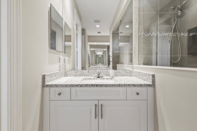 8369 Paladin Sq, Vero Beach, FL 32967 - bathroom with a tile shower, a textured wall, vanity, and recessed lighting