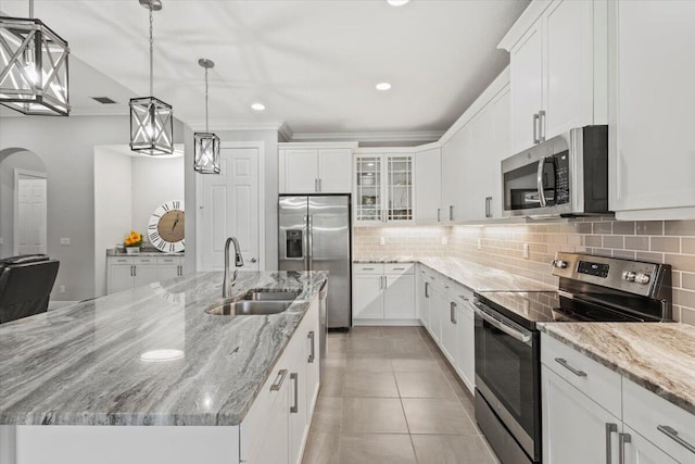 8369 Paladin Sq, Vero Beach, FL 32967 - kitchen with stainless steel appliances, a sink, decorative backsplash, a large island, and white cabinetry