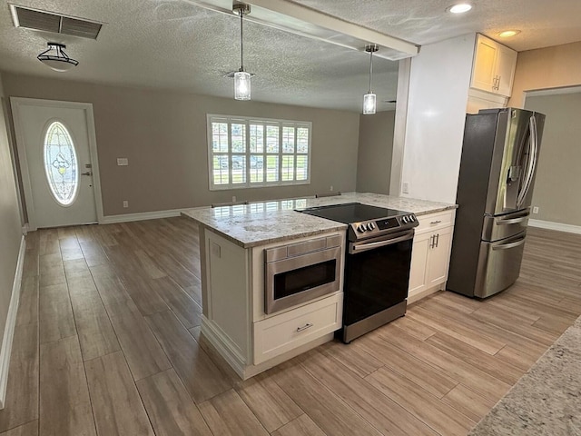 1807 Crafton Rd, North Palm Beach, FL 33408 - kitchen featuring stainless steel appliances, light wood-style flooring, baseboards, a textured ceiling, and open floor plan