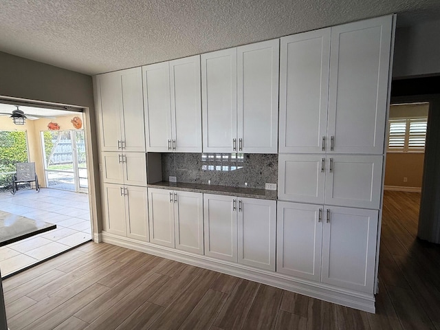 1807 Crafton Rd, North Palm Beach, FL 33408 - kitchen featuring dark wood-style floors, white cabinets, tasteful backsplash, a ceiling fan, and a textured ceiling