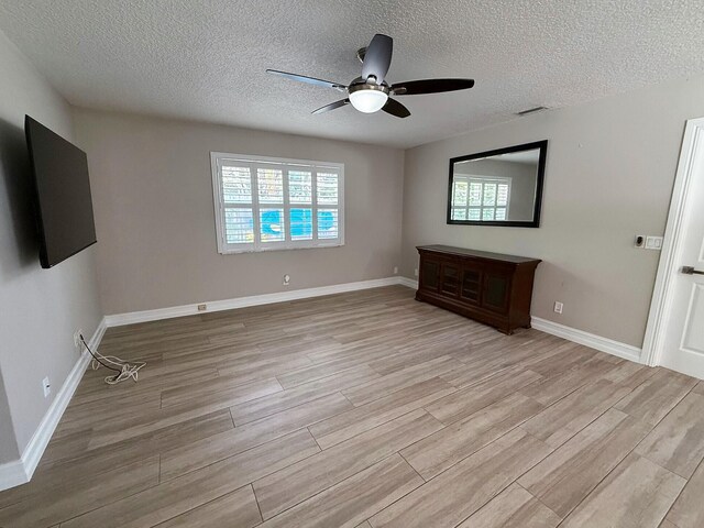 1807 Crafton Rd, North Palm Beach, FL 33408 - unfurnished bedroom with light wood-type flooring, multiple windows, a textured ceiling, ceiling fan, and baseboards