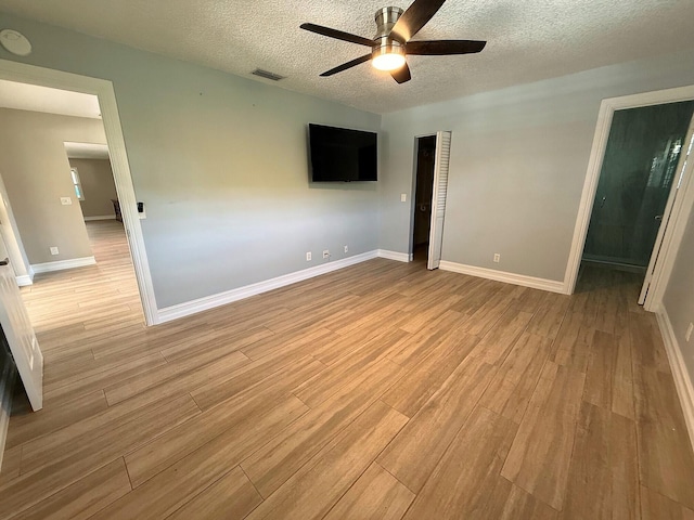 1807 Crafton Rd, North Palm Beach, FL 33408 - unfurnished bedroom featuring light wood-style flooring, a textured ceiling, baseboards, and ceiling fan