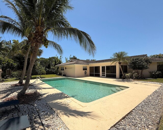 1807 Crafton Rd, North Palm Beach, FL 33408 - outdoor pool featuring a patio area and a sunroom