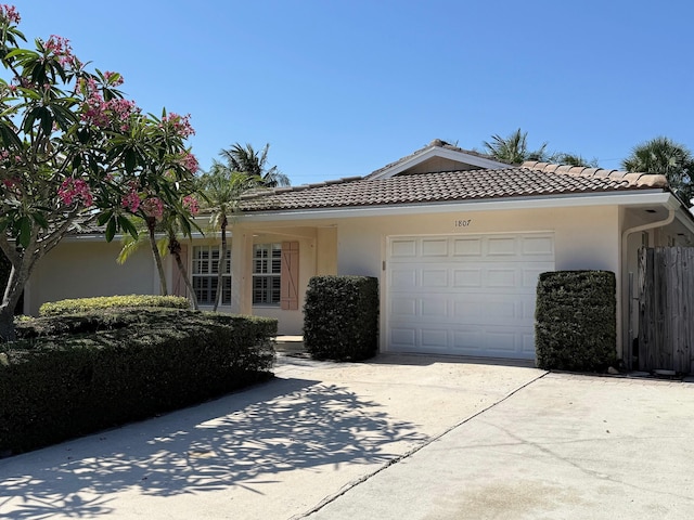 1807 Crafton Rd, North Palm Beach, FL 33408 - view of front of home featuring concrete driveway, stucco siding, an attached garage, and a tiled roof