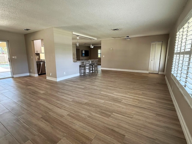 1807 Crafton Rd, North Palm Beach, FL 33408 - unfurnished living room with a textured ceiling, dark wood finished floors, and baseboards