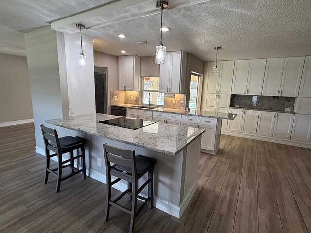 1807 Crafton Rd, North Palm Beach, FL 33408 - kitchen with a sink, dark wood-style flooring, a peninsula, white cabinetry, and baseboards