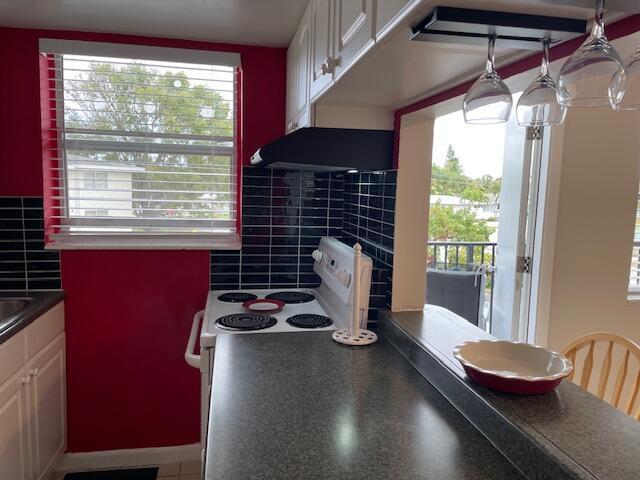 111 SE 1st St Unit 7, Boynton Beach, FL 33435 - kitchen featuring dark countertops and white cabinets