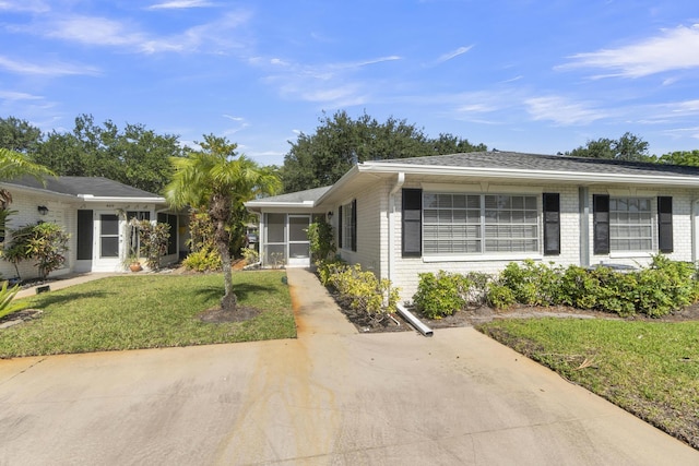10109 45th Trl S, Boynton Beach, FL 33436 - view of front of house with brick siding, a front yard, and a sunroom