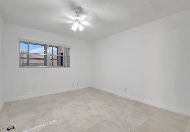spare room with baseboards and ceiling fan
