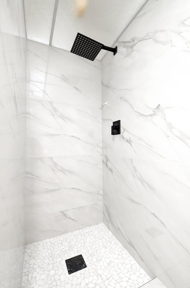 bathroom with a marble finish shower