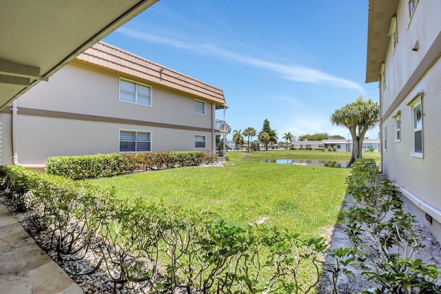 view of green lawn with a water view