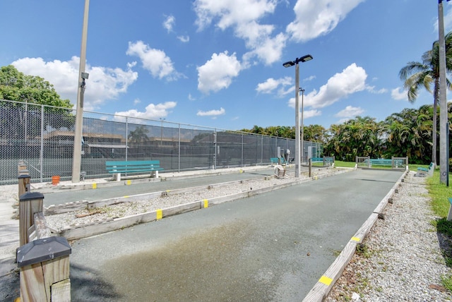 surrounding community featuring a game area, fence, and a tennis court