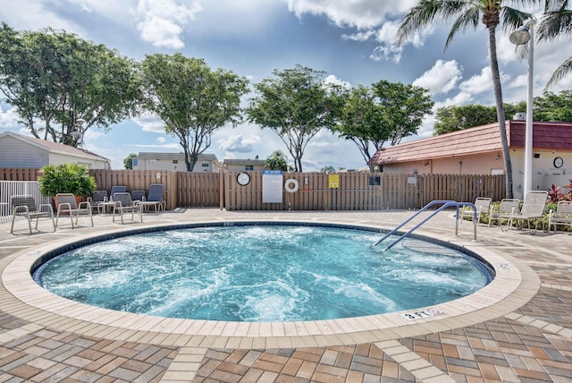 view of pool with a patio area, fence, and a swimming pool