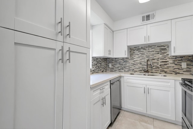 kitchen featuring a sink, appliances with stainless steel finishes, light countertops, and white cabinetry