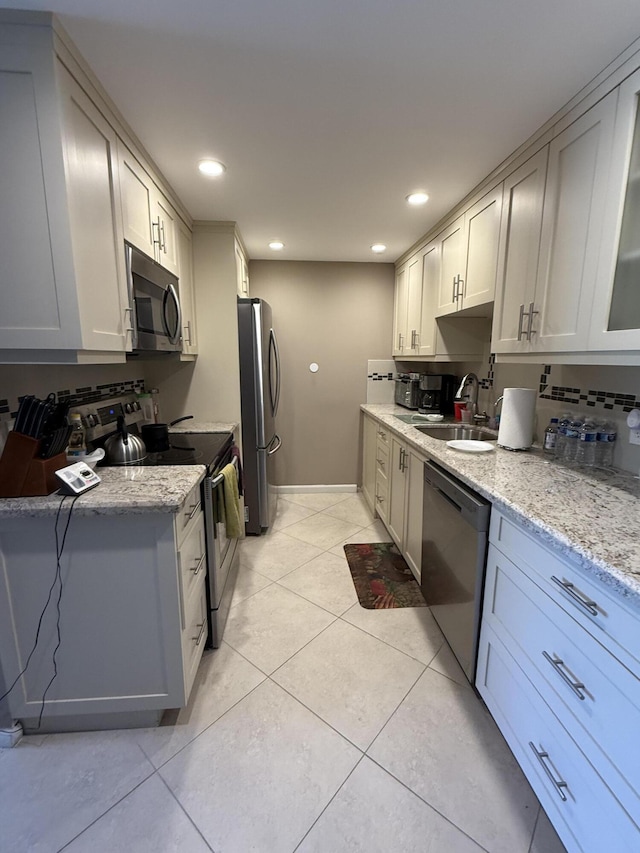 1008 Wolverton A, Boca Raton, FL 33434 - kitchen featuring appliances with stainless steel finishes, a sink, light stone countertops, light tile patterned floors, and recessed lighting