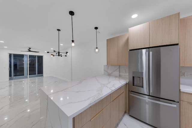 100 Paradise Harbour Blvd Unit 502, North Palm Beach, FL 33408 - kitchen with stainless steel fridge, light brown cabinetry, modern cabinets, a peninsula, and light stone countertops