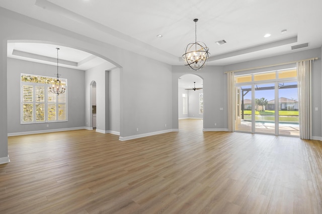 17009 SW Sapri Way, Port Saint Lucie, FL 34986 - unfurnished room featuring a tray ceiling, a chandelier, arched walkways, baseboards, and recessed lighting