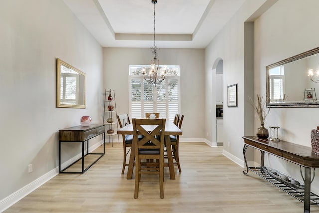 17009 SW Sapri Way, Port Saint Lucie, FL 34986 - dining room with arched walkways, a chandelier, a tray ceiling, and healthy amount of natural light