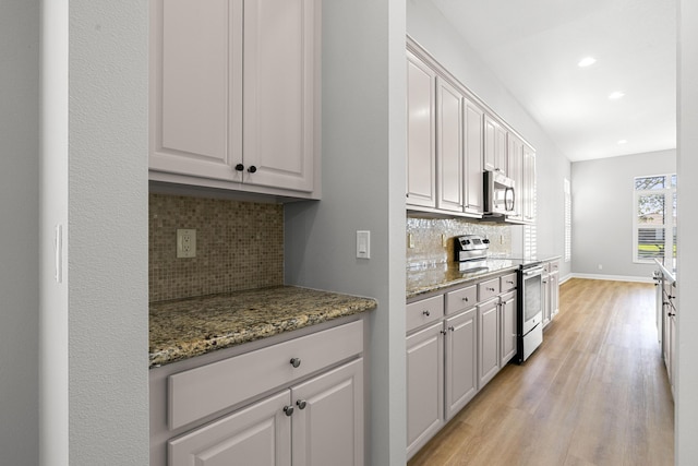 17009 SW Sapri Way, Port Saint Lucie, FL 34986 - kitchen with stainless steel appliances, light wood-type flooring, backsplash, recessed lighting, and baseboards