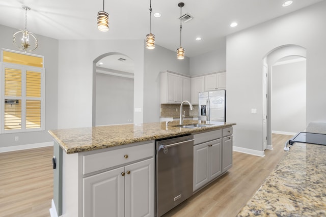 17009 SW Sapri Way, Port Saint Lucie, FL 34986 - kitchen with arched walkways, appliances with stainless steel finishes, light wood finished floors, a sink, and recessed lighting