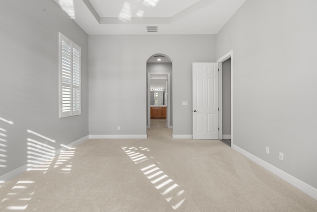 17009 SW Sapri Way, Port Saint Lucie, FL 34986 - empty room featuring arched walkways, light colored carpet, and baseboards