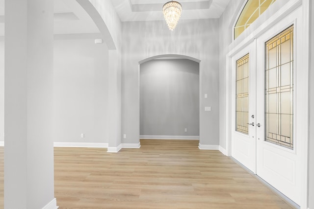 17009 SW Sapri Way, Port Saint Lucie, FL 34986 - foyer entrance featuring arched walkways, light wood-style flooring, baseboards, and a chandelier