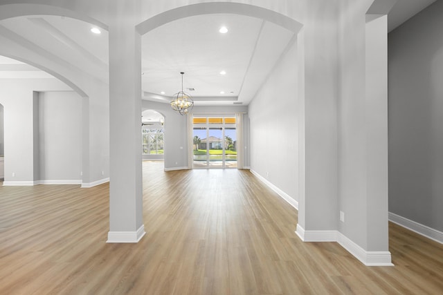 17009 SW Sapri Way, Port Saint Lucie, FL 34986 - unfurnished living room featuring arched walkways, light wood-style floors, recessed lighting, baseboards, and a chandelier