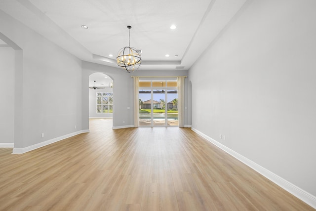 17009 SW Sapri Way, Port Saint Lucie, FL 34986 - unfurnished room featuring arched walkways, a chandelier, a tray ceiling, light wood-style floors, and recessed lighting