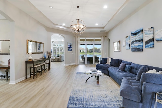 17009 SW Sapri Way, Port Saint Lucie, FL 34986 - living area with arched walkways, recessed lighting, a tray ceiling, light wood-style floors, and baseboards