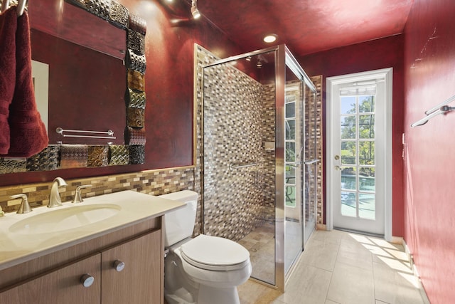bathroom featuring tile patterned flooring, toilet, vanity, and a stall shower