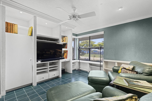 living room featuring tile patterned flooring, ornamental molding, a textured wall, a textured ceiling, and ceiling fan
