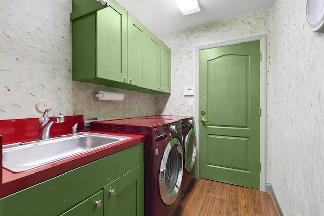 washroom with cabinet space, wood finished floors, washing machine and clothes dryer, and wallpapered walls