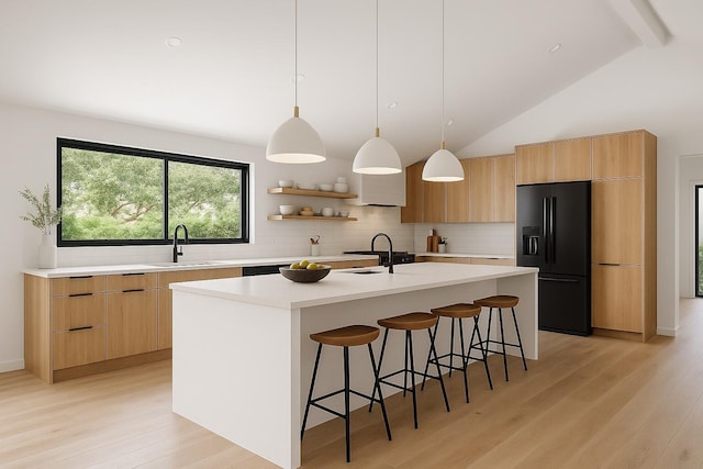 17902 Milburn Way, Boca Raton, FL 33498 - kitchen with black fridge, modern cabinets, tasteful backsplash, a kitchen bar, and light wood-style flooring