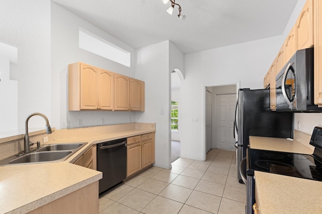 1042 SW Janette Ave, Port Saint Lucie, FL 34953 - kitchen with stainless steel appliances, light brown cabinetry, light countertops, light tile patterned floors, and arched walkways