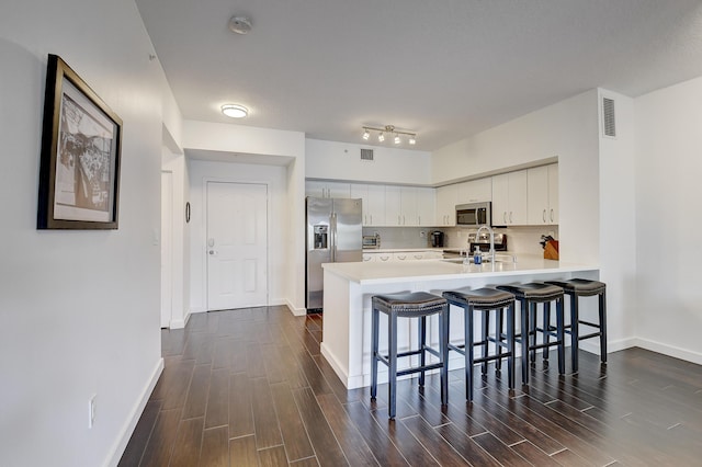 255 NE 3rd Ave Unit 2-516, Delray Beach, FL 33444 - kitchen with stainless steel appliances, a peninsula, dark wood finished floors, light countertops, and a kitchen breakfast bar