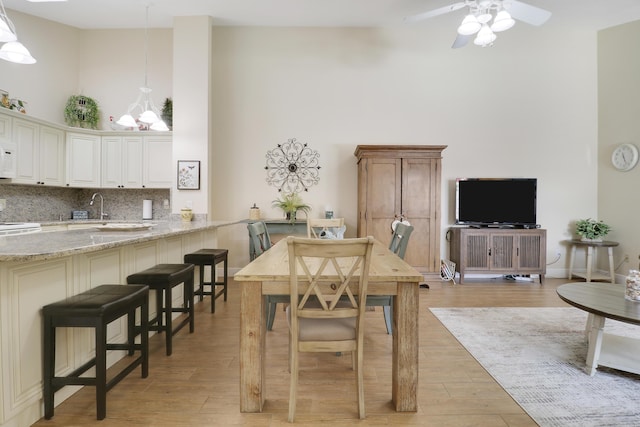 1801 S US Highway 1 Unit 7C, Jupiter, FL 33477 - dining room featuring a towering ceiling, a ceiling fan, and light wood-style floors