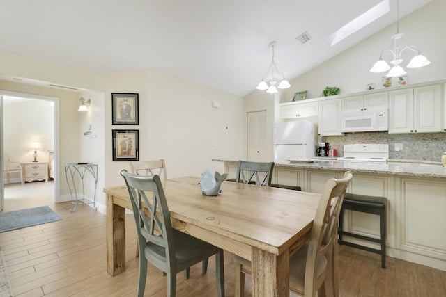 1801 S US Highway 1 Unit 7C, Jupiter, FL 33477 - dining space with a chandelier, a skylight, lofted ceiling, and light wood-type flooring