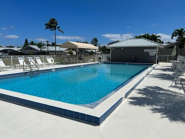 community pool with fence and a patio