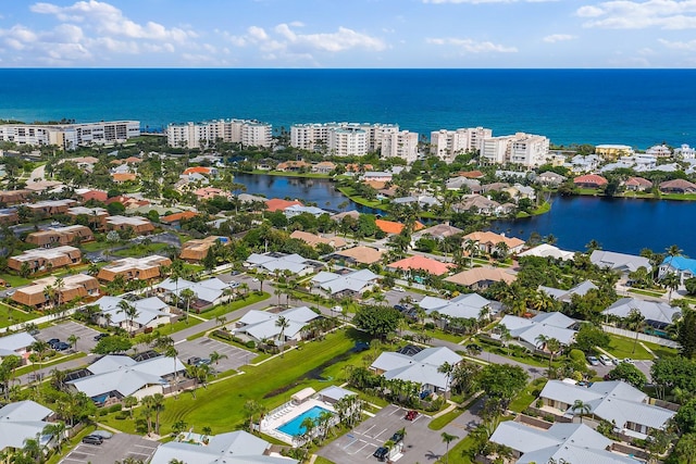 aerial view of property and surrounding area featuring a nearby body of water and nearby suburban area