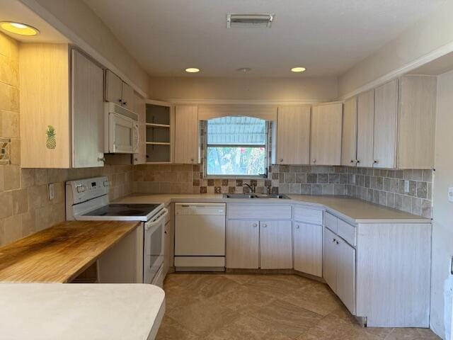 kitchen with white appliances, a sink, light countertops, backsplash, and open shelves