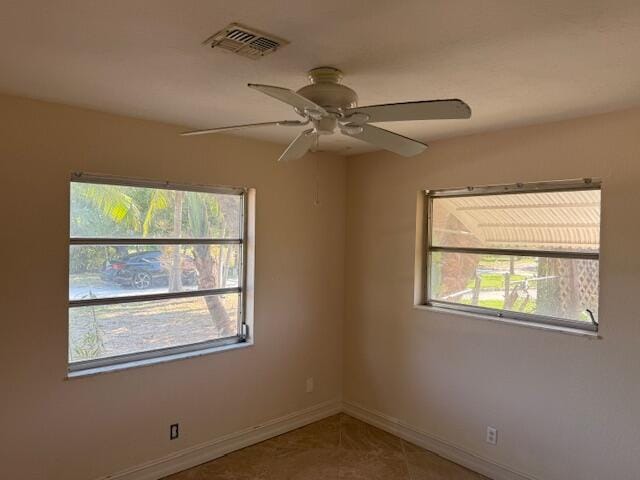unfurnished room with healthy amount of natural light, baseboards, and a ceiling fan