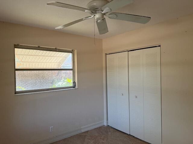 unfurnished bedroom featuring a closet, ceiling fan, and baseboards