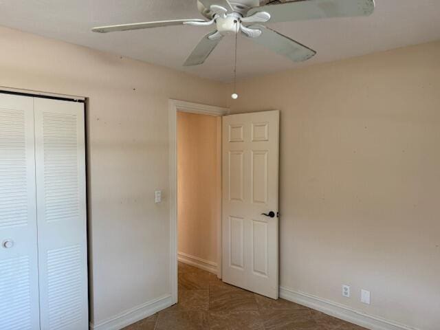 unfurnished bedroom featuring a closet, baseboards, and a ceiling fan