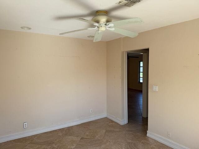empty room with ceiling fan and baseboards