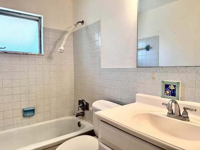 full bathroom with tile walls, shower / washtub combination, toilet, and vanity