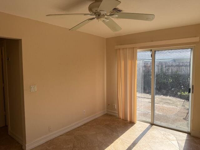 tiled spare room featuring a ceiling fan and baseboards