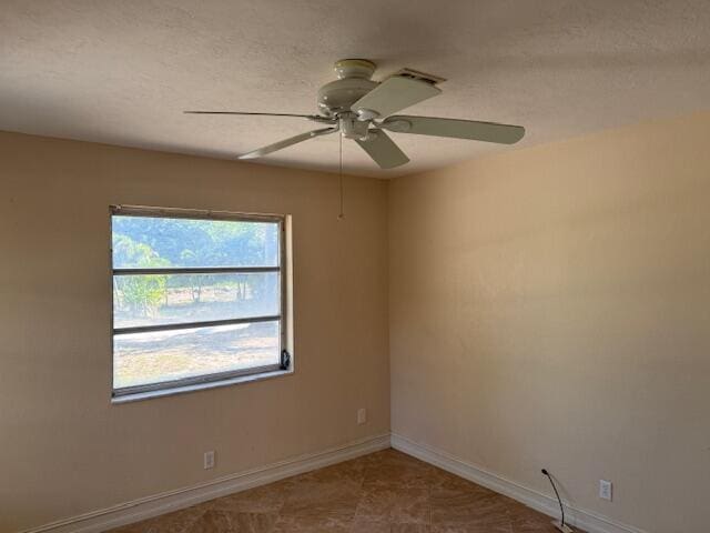 spare room with baseboards and ceiling fan