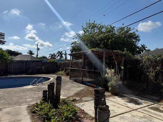 view of swimming pool with a fenced backyard and a patio area