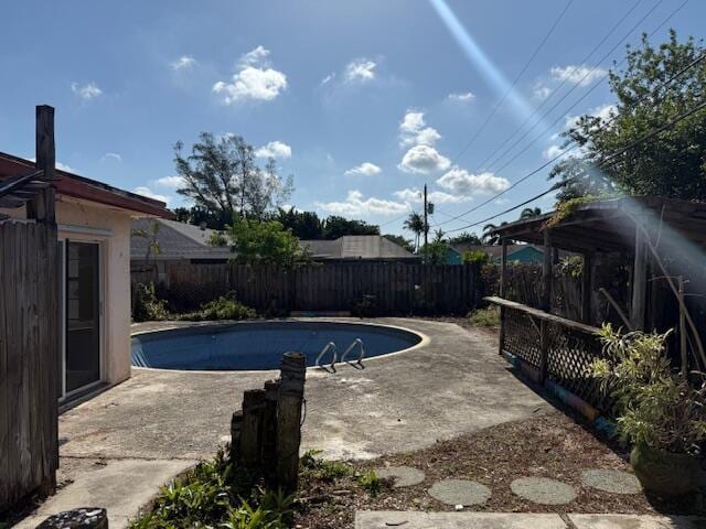 view of pool with a fenced backyard and a patio