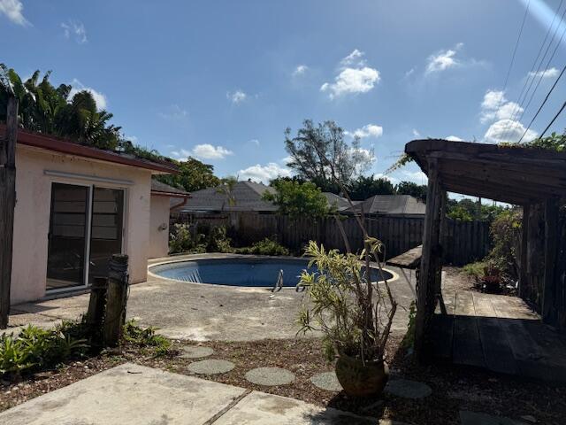 view of swimming pool with a fenced backyard and a patio area